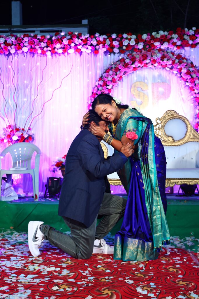 A couple sharing a joyful moment during a colorful engagement ceremony in Hyderabad.