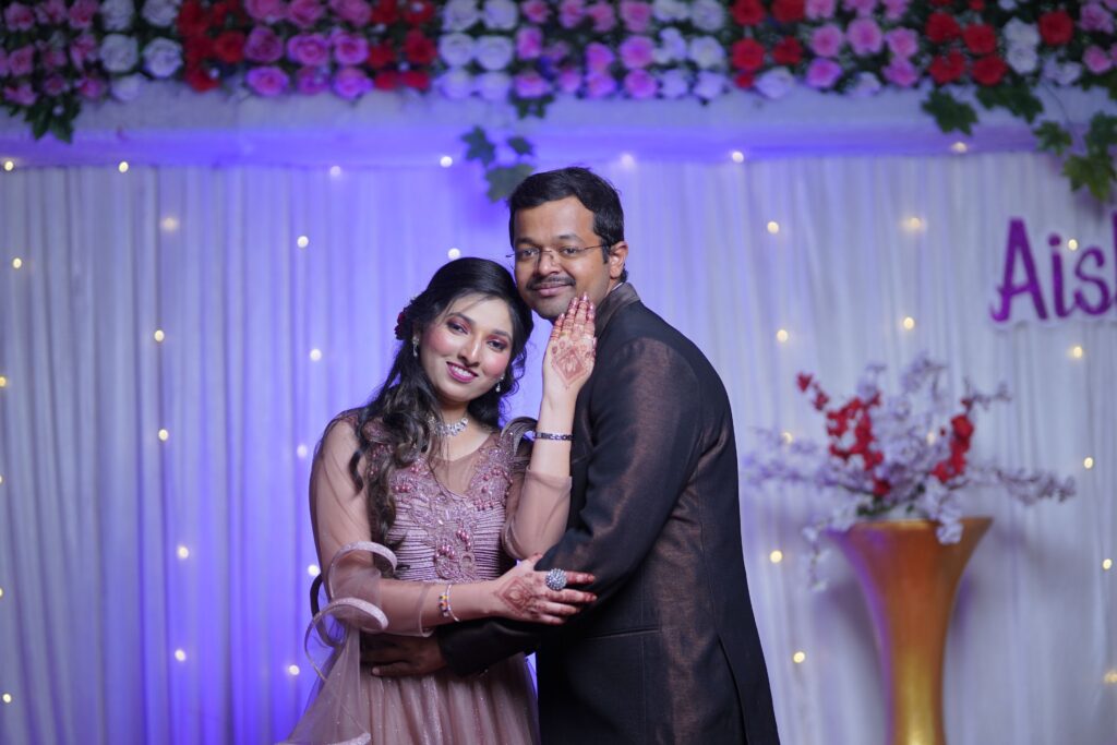 Elegant South Asian couple in traditional attire at a vibrant wedding celebration.