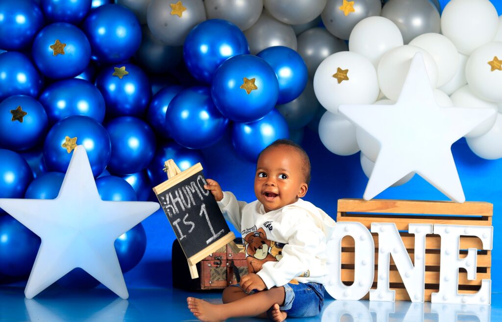 Cute baby enjoys first birthday celebration with star-themed decorations and balloons.