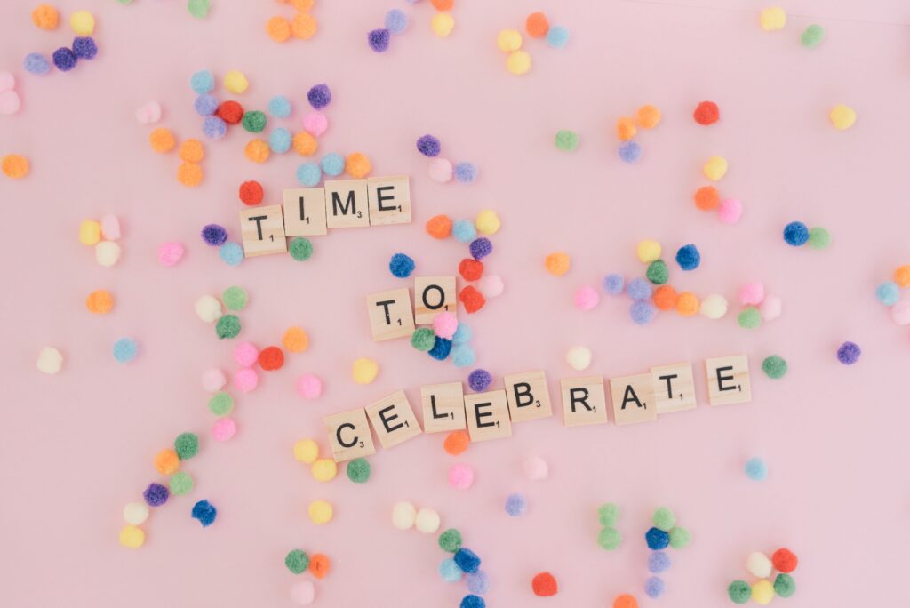 Bright and cheerful celebration concept with colorful confetti and scrabble tiles spelling 'Time to Celebrate'.